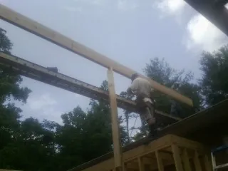 Carpenter setting a ridge beam over a new addition frame — Ice Dam Removal by Roofing Brothers in Jessup