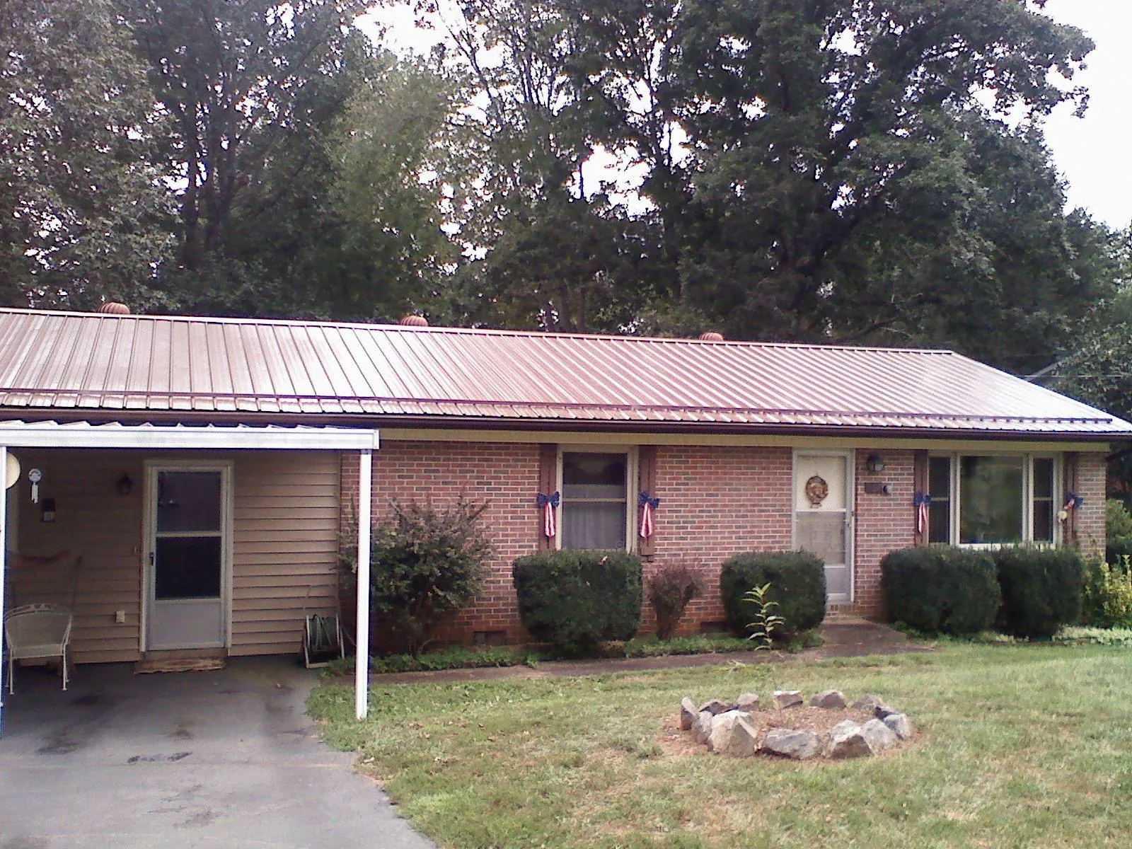 Bronze metal roof and carport on a brick ranch home — Roof Repair work by our crew in Jessup