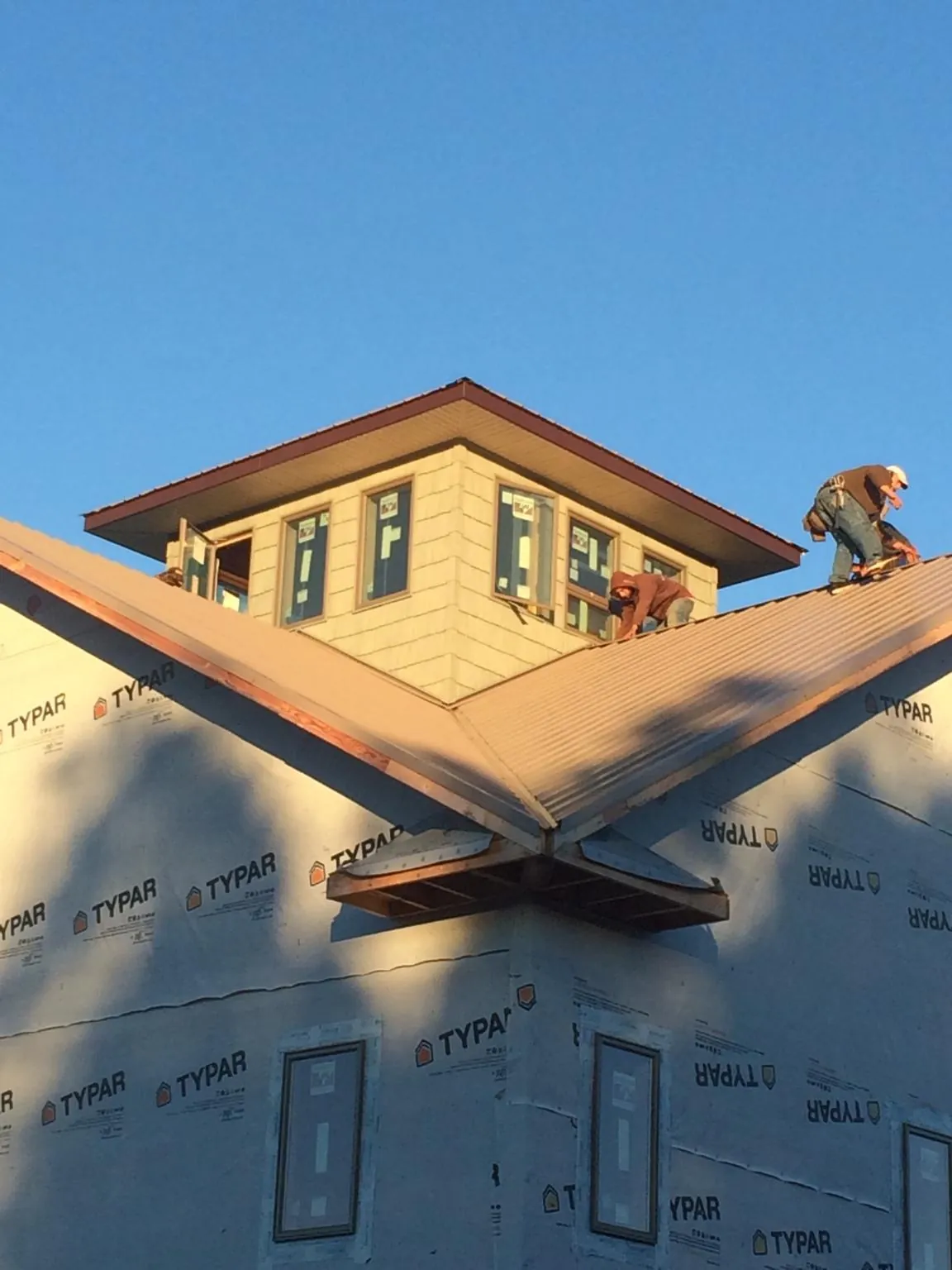 Roofers working around a rooftop cupola on a new metal roof at sunset — Roof Waterproofing in Jessup by Roofing Brothers